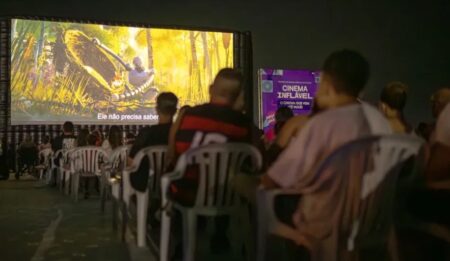 Cinema Inflável em Maricá transforma orla em cinema gratuito Cinema ao ar livre com famílias assistindo filme no Parque Nanci em Maricá